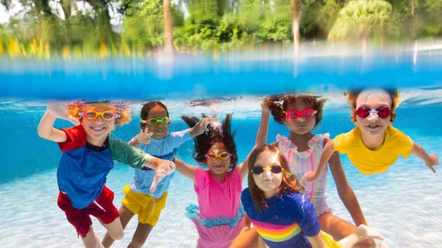 Children swimming underwater in a pool 